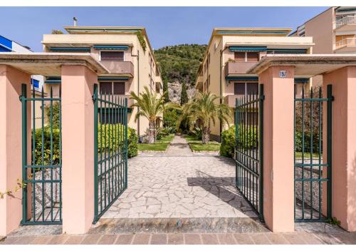 a gate to a villa with palm trees at Diamante Sea Apartment - Eleganza sul Mare in Varigotti