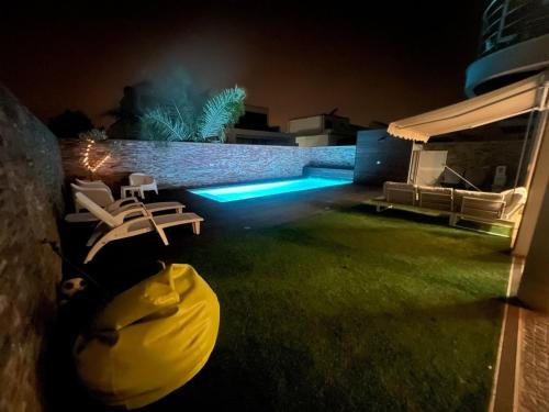a backyard at night with a pool and chairs at GuestReady - A fantastic retreat in Valongo in Valongo