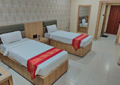 a bedroom with two beds and a mirror at Hotel Richi Regency Bhubaneswar in Bhubaneshwar