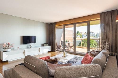 a living room with two couches and a tv at GuestReady - Freixo lux with Douro River view in Porto