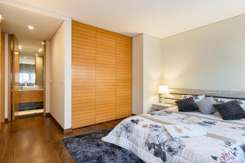 1 dormitorio con una gran pared de madera en GuestReady - Freixo lux with Douro River view, en Oporto