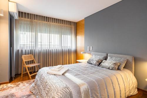 1 dormitorio con cama y ventana grande en GuestReady - Freixo lux with Douro River view, en Oporto