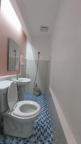 ein Badezimmer mit einem weißen WC und einem Waschbecken in der Unterkunft PrimeRose Residences in Lapu Lapu City