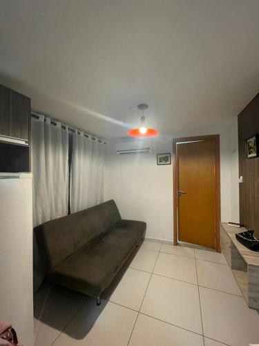 a living room with a couch and a brown door at ISRAEL TAMBAÚ- Apto Luxuoso- Em frente ao Mar com Varanda in João Pessoa
