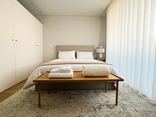 1 dormitorio con cama y mesa de madera en GuestReady - Senhora da Hora stay near City Golf en Senhora da Hora