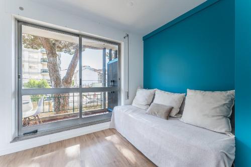 a room with a couch and a large window at GuestReady - Shades of Blue with Balcony in Porto