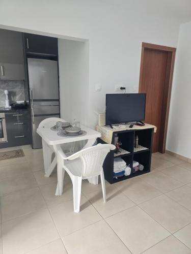 kuchnia z białym stołem, białym stołem i krzesłami w obiekcie Monda Apartment w Pireusie