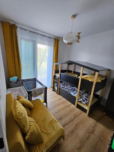 a living room with two bunk beds and a couch at VistaHub Baltic in Niechorze