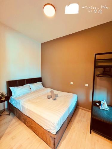 a bedroom with a large bed with a brown wall at Maison life 小居屋 Jesselton Quay CityPads in Kota Kinabalu
