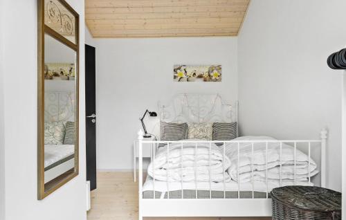 1 dormitorio con cama blanca y espejo en Stunning Home In Stege With Kitchen, en Stege
