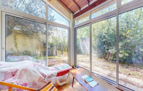 une chambre avec un lit, une table et des fenêtres dans l'établissement 3 Bedroom Gorgeous Home In Royan, à Royan