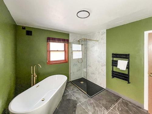 a green bathroom with a tub and a shower at Innish Beag - Uk38782 in Clachan