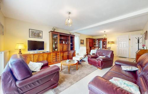 a living room with leather furniture and a flat screen tv at Awesome Home In Blonville-Sur-Mer in Blonville-sur-Mer