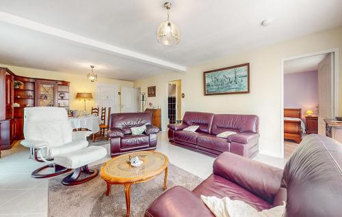 a living room with leather furniture and a table at Awesome Home In Blonville-Sur-Mer in Blonville-sur-Mer