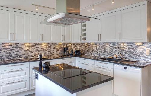 a kitchen with white cabinets and a black counter top at 1 Bedroom Amazing Home In Hörby in Hörby