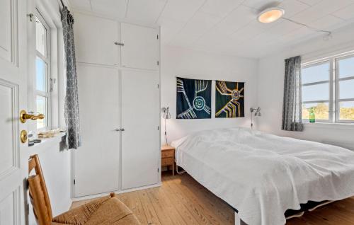 a white bedroom with a bed and a window at Awesome Home In Fan With House A Panoramic View in Fanø