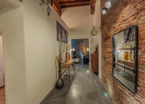 pasillo con pared de ladrillo, mesa y espejo en Luxury Apartament Florence, en Florencia