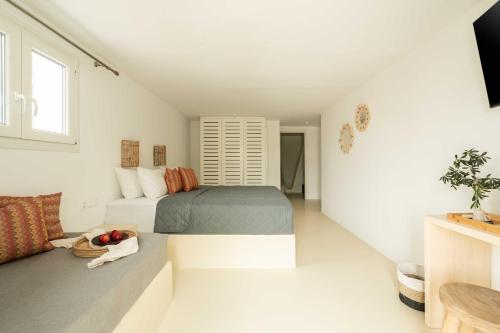 a white room with two beds and a couch at Tagoo Studios Mykonos in Mýkonos City
