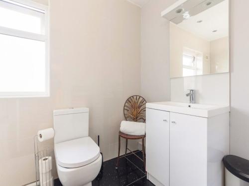 a white bathroom with a toilet and a sink at Holbrook House in Cambridge
