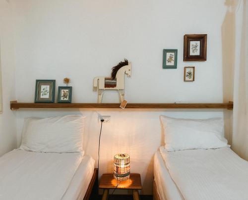 1 dormitorio con 2 camas y una lámpara en una mesa en Blue House In The Woods- Amirim en Amirim