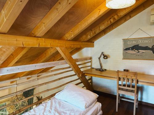a bedroom with a desk and a bed in a attic at Blue House In The Woods- Amirim in Amirim