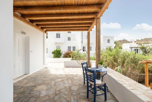 a patio with two chairs and a table on a roof at Tagoo Studios Mykonos in Mýkonos City