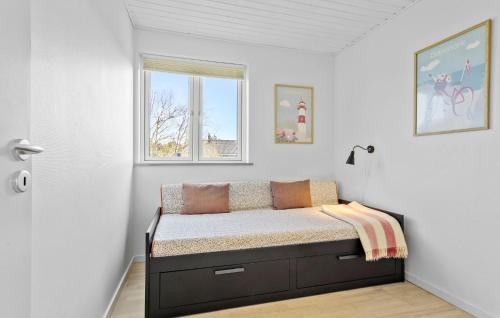 ein kleines Bett in einem Zimmer mit Fenster in der Unterkunft 3 Bedroom Beautiful Home In Frederikshavn in Frederikshavn
