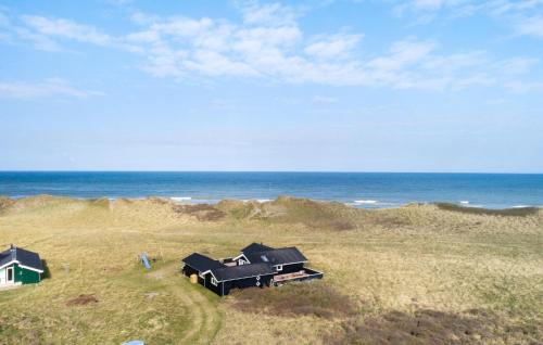 two houses on the beach near the ocean at Beach Front Home In Hjørring With Sauna in Hjørring