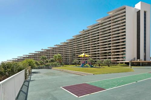 a large building with a tennis court in front of it at Edgewater #303 in Destin