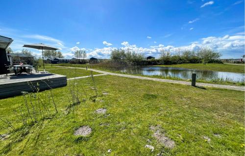 a grassy field with a path next to a river at Pet Friendly Home In Lauwersoog in Lauwersoog