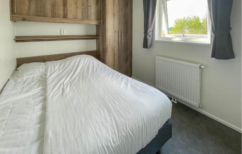a bedroom with a white bed with a window at Pet Friendly Home In Lauwersoog in Lauwersoog