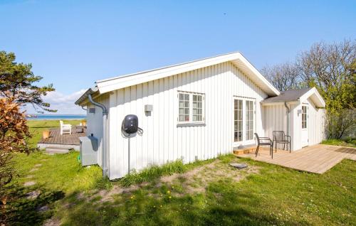 a small white house with a wooden deck at Three-Bedroom Holiday Home In Knebel in Knebel
