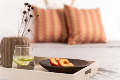a table with a bowl of apples and a glass of lime at Tagoo Studios Mykonos in Mýkonos City