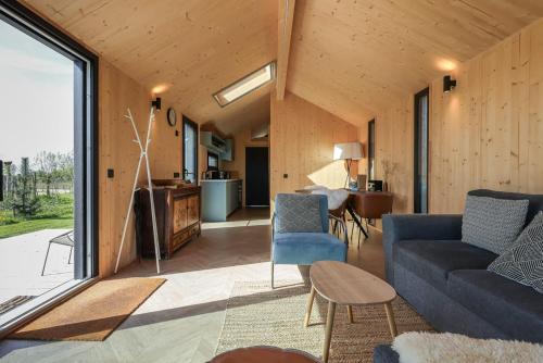 ヴェストカペレにあるHello Zeeland - Tiny House Zeeuwse Liefde 2の青いソファとテーブルのあるリビングルーム