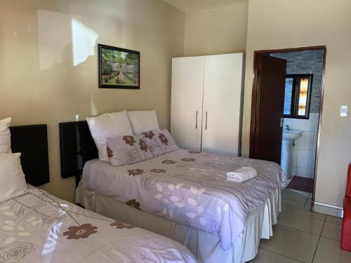 1 dormitorio con 2 camas y baño en M & J HOTELS en Johannesburgo