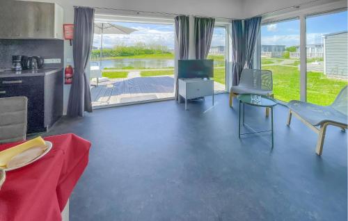 a living room with a television and a table and chairs at 2 Bedroom Awesome Home In Lauwersoog in Lauwersoog