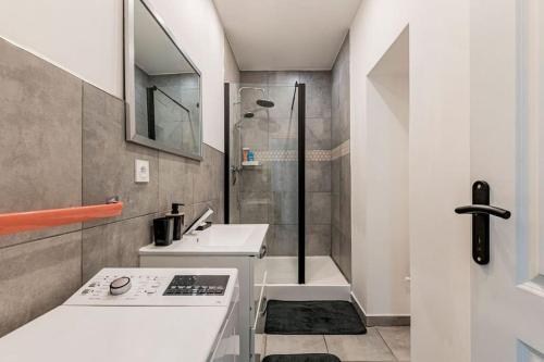 une salle de bain blanche avec une douche et un lavabo dans l'établissement Le Zénith spacieux et central, à Saint-Étienne
