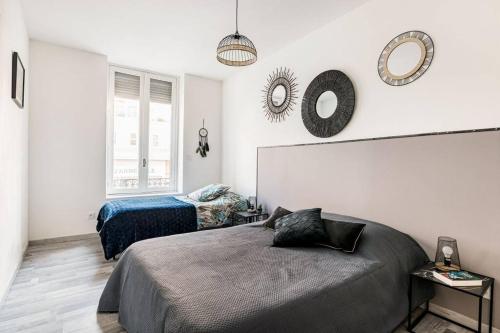 - une chambre avec 2 lits et 2 miroirs sur le mur dans l'établissement Le Zénith spacieux et central, à Saint-Étienne