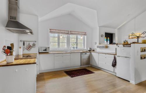 Una cocina con gabinetes blancos y una ventana grande. en Amazing Home In Sæby With Wifi, en Saeby