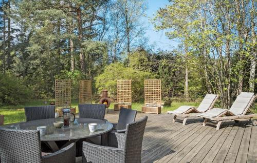 a patio with a table and chairs on a wooden deck at 4 Bedroom Amazing Home In Vig in Vig