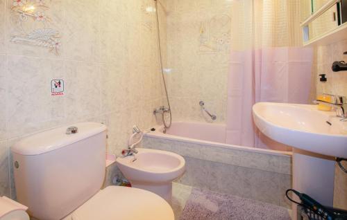 biała łazienka z toaletą i umywalką w obiekcie Cozy Apartment In Torrevieja With Outdoor Swimming Pool w mieście Torrevieja