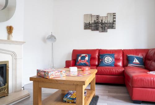 a living room with a red couch and a coffee table at I know you'll love this house 5min walk from beach in Great Yarmouth
