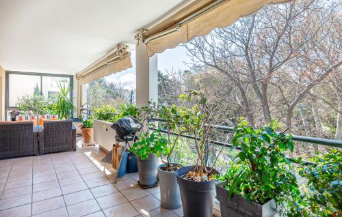 Elle comprend un balcon avec des plantes en pot et une grande fenêtre. dans l'établissement Beautiful Apartment In Marseille, à Marseille