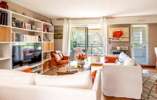 Il comprend un salon doté d'un mobilier blanc et d'une télévision. dans l'établissement Beautiful Apartment In Marseille, à Marseille