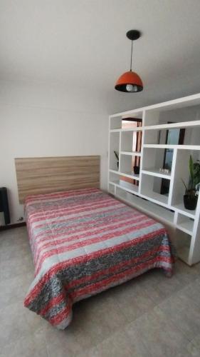 Un dormitorio con una cama con una manta roja. en San Martín 3510 OK en Mar del Plata
