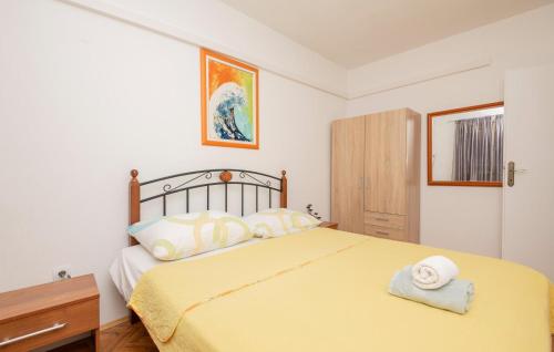 1 dormitorio con 1 cama con colcha amarilla en Cozy Apartment In Makarska With Kitchen en Makarska