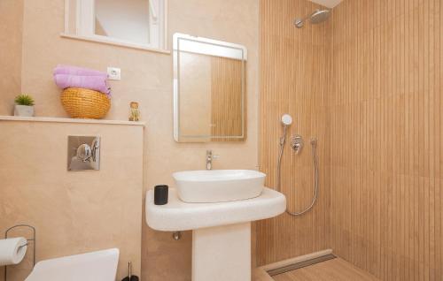 y baño con lavabo blanco y ducha. en Cozy Apartment In Makarska With Kitchen en Makarska