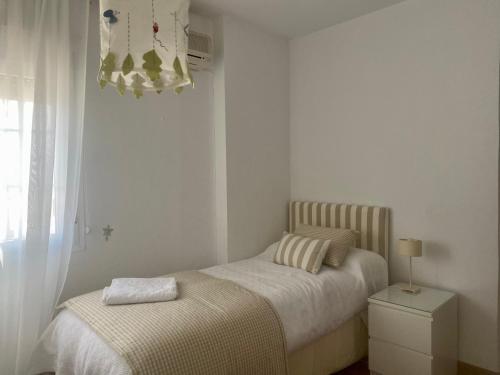 ein kleines Schlafzimmer mit einem Bett und einem Fenster in der Unterkunft Casa Paloseto in Higuera de la Sierra