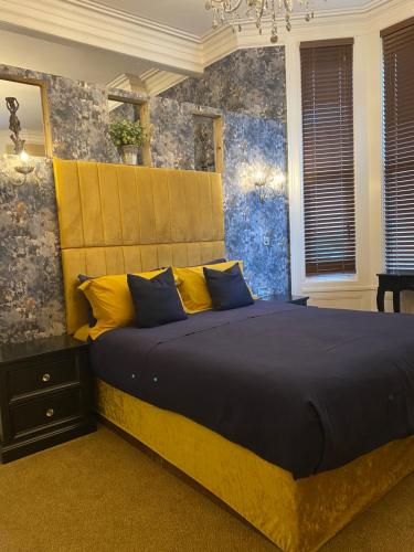 a bedroom with a large bed with yellow and blue pillows at The New Talbot Hotel in Southport