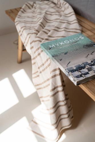 a book sitting on top of a wooden table at Tagoo Studios Mykonos in Mýkonos City